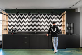 Innenarchitektur Office Asphaltgold Darmstadt - urbane Teeküche mit Zickzackmuster-Fliesen, schwarzer Küchenfront und Akzenten in grün 