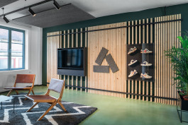 Innenarchitektur Office Asphaltgold Darmstadt - Loungebereich mit TV und Präsentationswand im Lamellendesign 