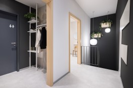 Innenarchitektur Zahnarztpraxis Darmstadt - Erschließungsbereich mit Garderobe und Pflanzen, Blick auf Logowand 