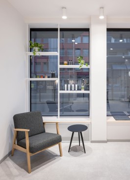 Innenarchitektur Zahnarztpraxis Darmstadt - Blick auf Sessel vor Schaufenster mit Präsentationsregal 