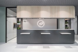 Innenarchitektur Zahnarztpraxis Darmstadt - Sicht auf Anmeldung mit beleuchtetem Logoelement 