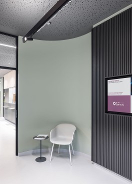 Innenarchitektur Zahnarztpraxis Darmstadt - Ansicht auf Wand mit Holzlamellen und Stuhl zum Warten 