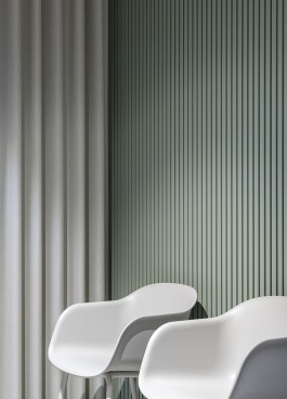 Innenarchitektur Zahnarztpraxis Darmstadt - Wartezimmer mit Stühlen vor grüner Lattenwand 