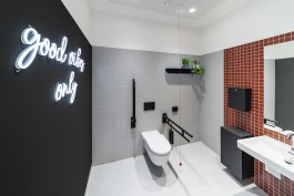 Sanitätshaus Behrmann Darmstadt Innenarchitektur Design WC barrierefrei Mosaikfliesen rot und grau Neonschriftzug 