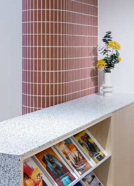 Reisebüro Einhausen Innenarchitektur Design - Detailblick auf Terrazzo- und Ahornholzmöbel, Säule mit Mosaikfliesen 
